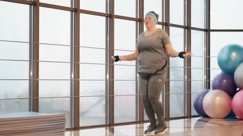 Woman with Excess Weight Workout Tirelessly at a Gym