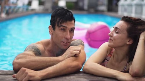 Confident Handsome Middle Eastern Man Flirting with Caucasian Woman at Poolside in Hotel Outdoors