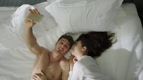 Paar schaut sich drinnen an. Sexy Guy Girl Liegend Bett im luxuriösen Hotelzimmer.