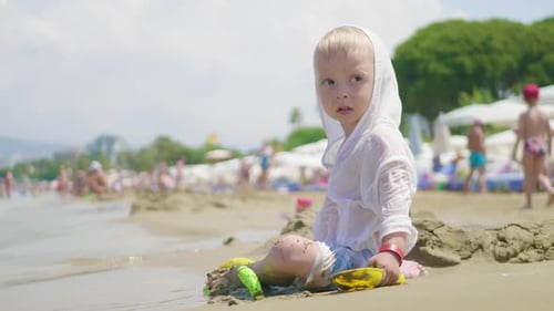 The Cute Little Boy Playing Toys with Sand at Sea Beach. Child Os on Vacation in Summer at the Beach