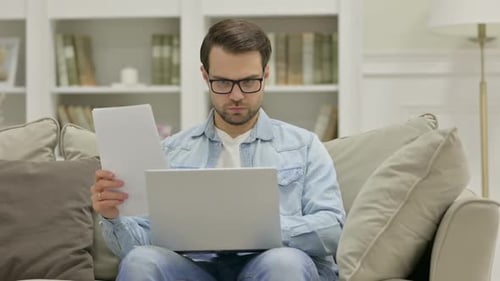Man Working on Laptop at Home on Couch
