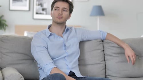 Pensive Creative Young Man Thinking While Sitting on Couch