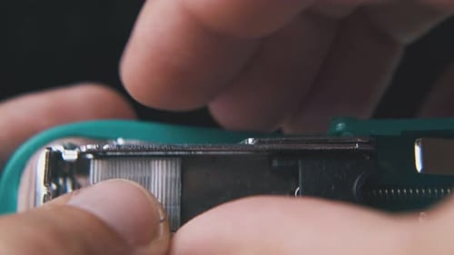 Close Up of Hand Loading Teal Office Stapler