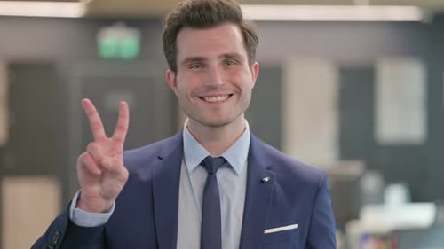 Young Man Gives Peace Sign in Office Setting