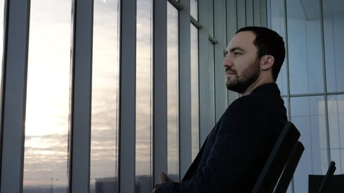 Contemplative Man Sitting, Looking Out City Window