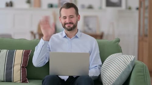 Man on Couch Using Laptop for Video Call