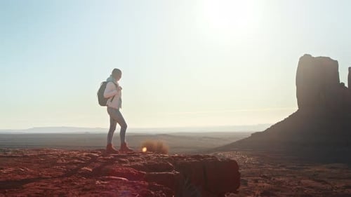 Abenteuerlustige Frau auf einer Klippe mit Blick auf die wunderschöne Landschaft im Monument Valley