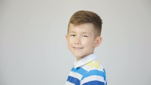 Smiling Boy Poses in Blue and White Shirt