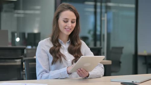 Woman Works on Tablet in Modern Office
