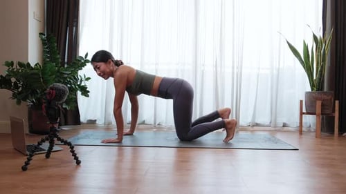 Woman Does Yoga on Mat in Bright Room