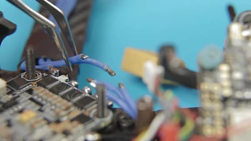 Löten von ESC-Kontakten. Extreme Nahaufnahme der Hände eines jungen Mannes beim Zusammenbau der FPV-Renndrohne.