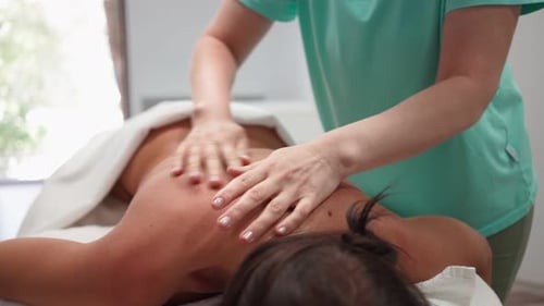 Schöne Frau mit perfekter Hautentspannung bei Rücken- und Schultermassage