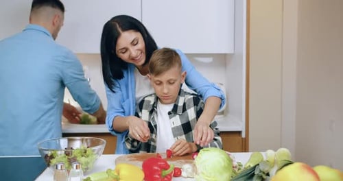 Mother and Son Preparing Salad in Kitchen