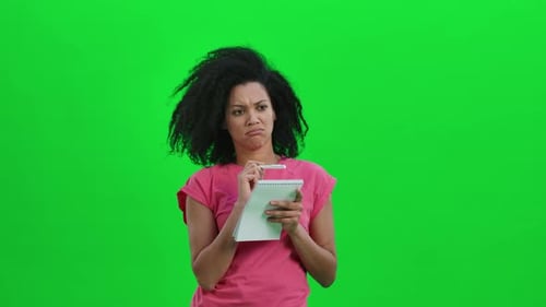 Woman with Notepad Thinking and Writing on Greenscreen