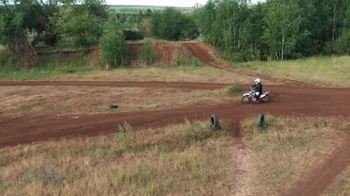 Two Motorcyclists Riding on Dirt Track in Forest