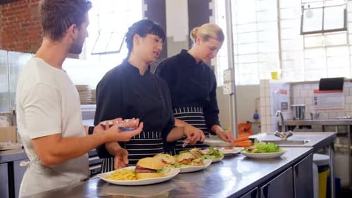Restaurant Workers Preparing Food Orders in Kitchen