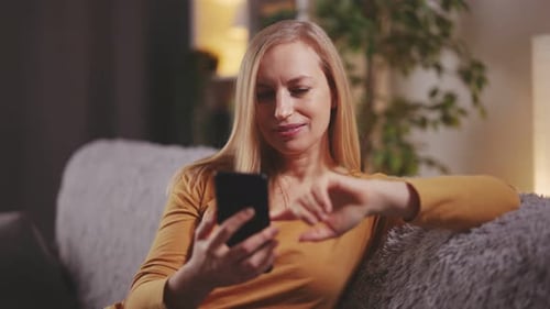 Woman Relaxing at Home, Using Phone