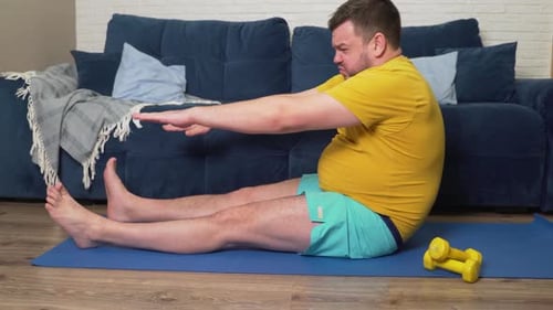 Man Stretching on a Yoga Mat Indoors