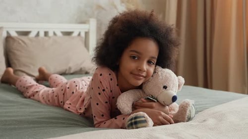 Girl Hugging Teddy Bear Lying on Bed