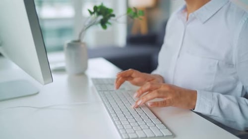 Woman Typing on Keyboard in Bright Office