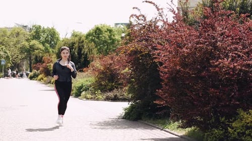 Pretty Athletic Woman Is Jogging Outdoors