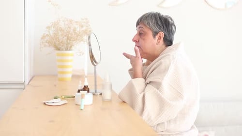 Woman Applying Skincare Products for Facial Treatment