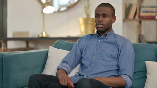Man Coughing While Sitting on the Couch Indoors
