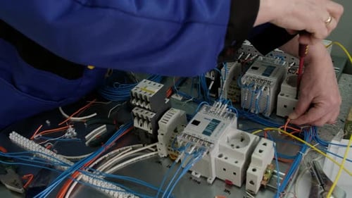 Electrician Wiring Electrical Panel with Screwdriver