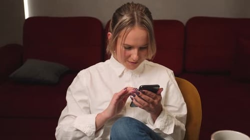 Young Woman Using Smartphone in Cozy Home Setting
