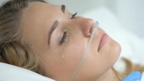 Patiente déprimée avec la canule nasale regardant la caméra, handicap de maladie