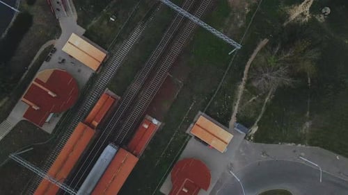 Railway station in the suburbs. A train passes through the station.