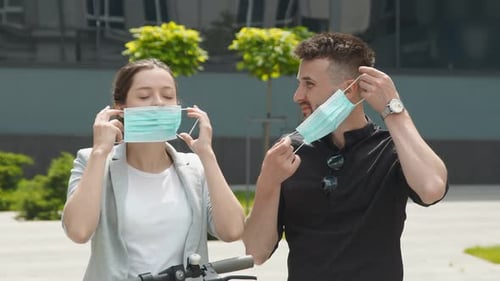 Young People on the Street Wear Protective Masks and Communicate with Each Other. Two Men and a