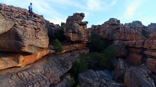 Male rock climber standing over a rocky mountain 4k