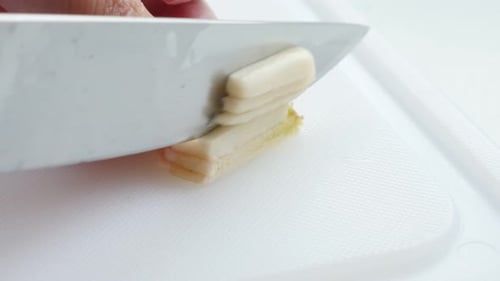 Scallions Being Sliced on a White Cutting Board