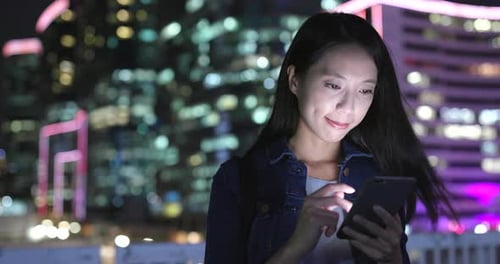 Woman Using Mobile Phone at Night in City