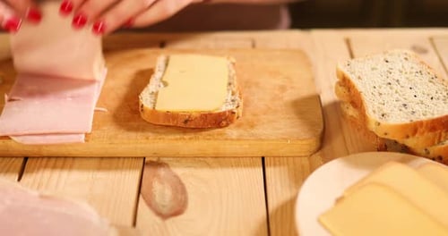Woman Makes a Ham and Cheese Sandwich