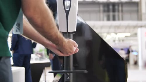 Man using automatic sanitizing dispenser with antiseptic