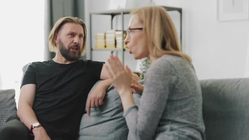 Couple Arguing on a Couch During the Day