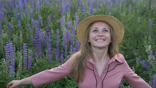 Girl in Pink Dress and Straw Hat Turns Around in Lupin Field