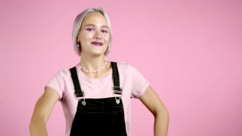Beautiful Hipster Woman Dancing with Colorful Hairstyle Energetically and Actively on Pink Studio