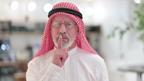 Senior Man Gesturing for Silence Indoors
