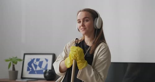 Woman Sings Along with Mop in Home