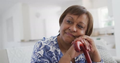 Thoughtful Woman Resting with Cane Indoors