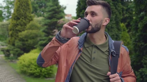 Handsome Stylish Man Drinking Coffee in Green City Park