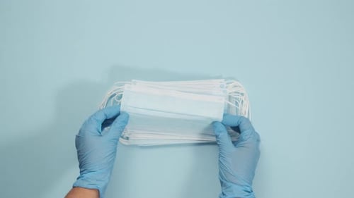 Medical Masks Arranged on Light Blue Surface