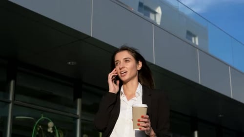 Young Woman Talking on Phone, Walking in City