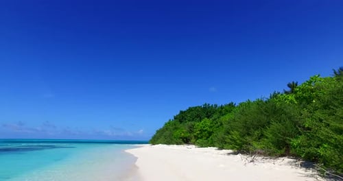 Wide angle flying abstract shot of a white paradise beach and turquoise sea background in 4K