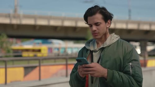 Happy Guy with Piercing Standing on Street and Using Mobile