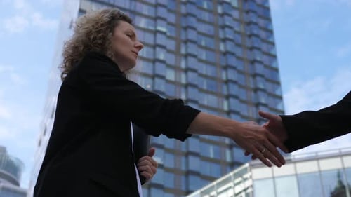 Satisfied Caucasian Business Woman Shakes Hand with Her Business Partner As They Close the Deal