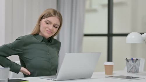 Young Woman Experiences Back Pain at her Desk
